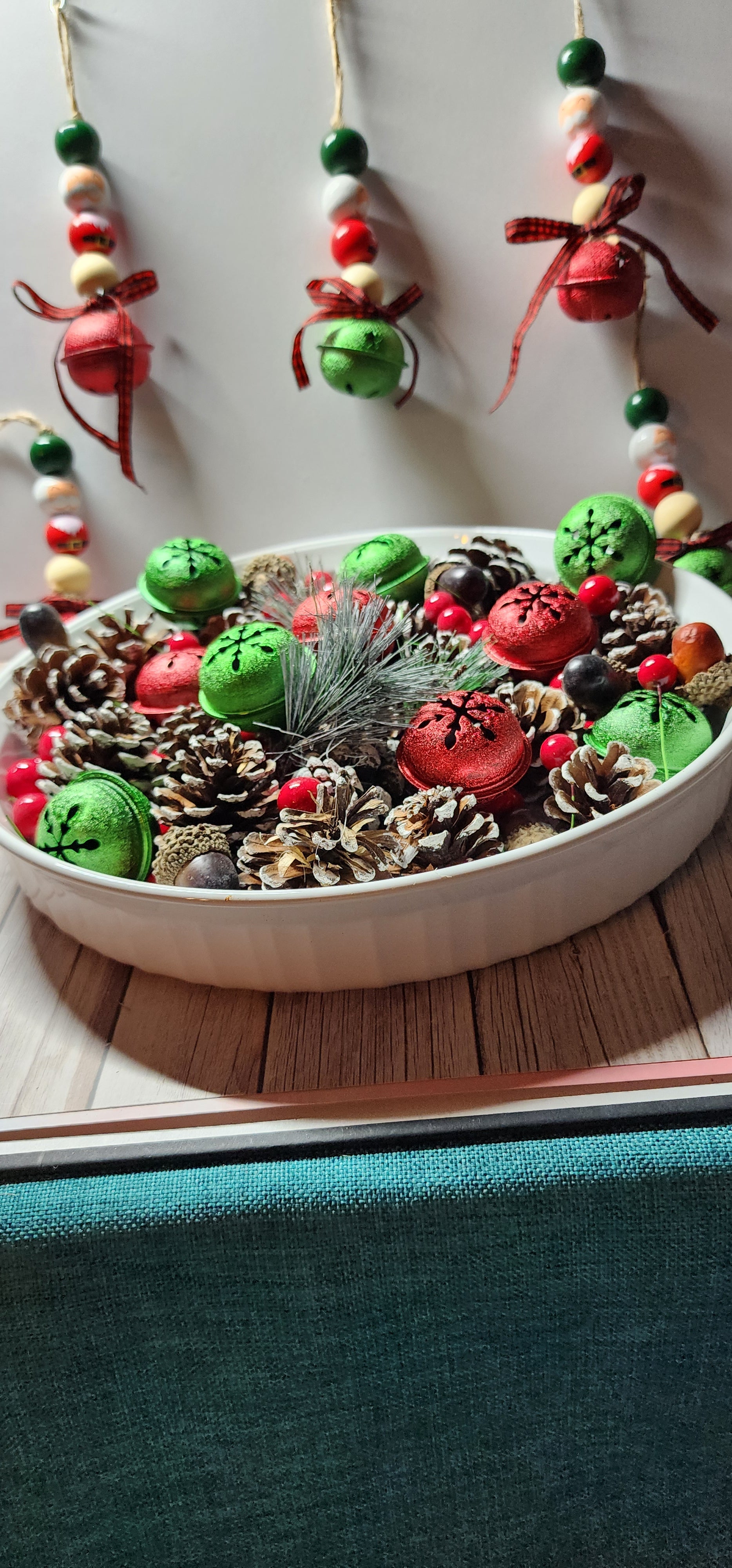 Wooden Christmas ornaments with Santa Claus beads and large green and red jingle bells. Buffalo plaid ribbon on bottom. Whimsical decor