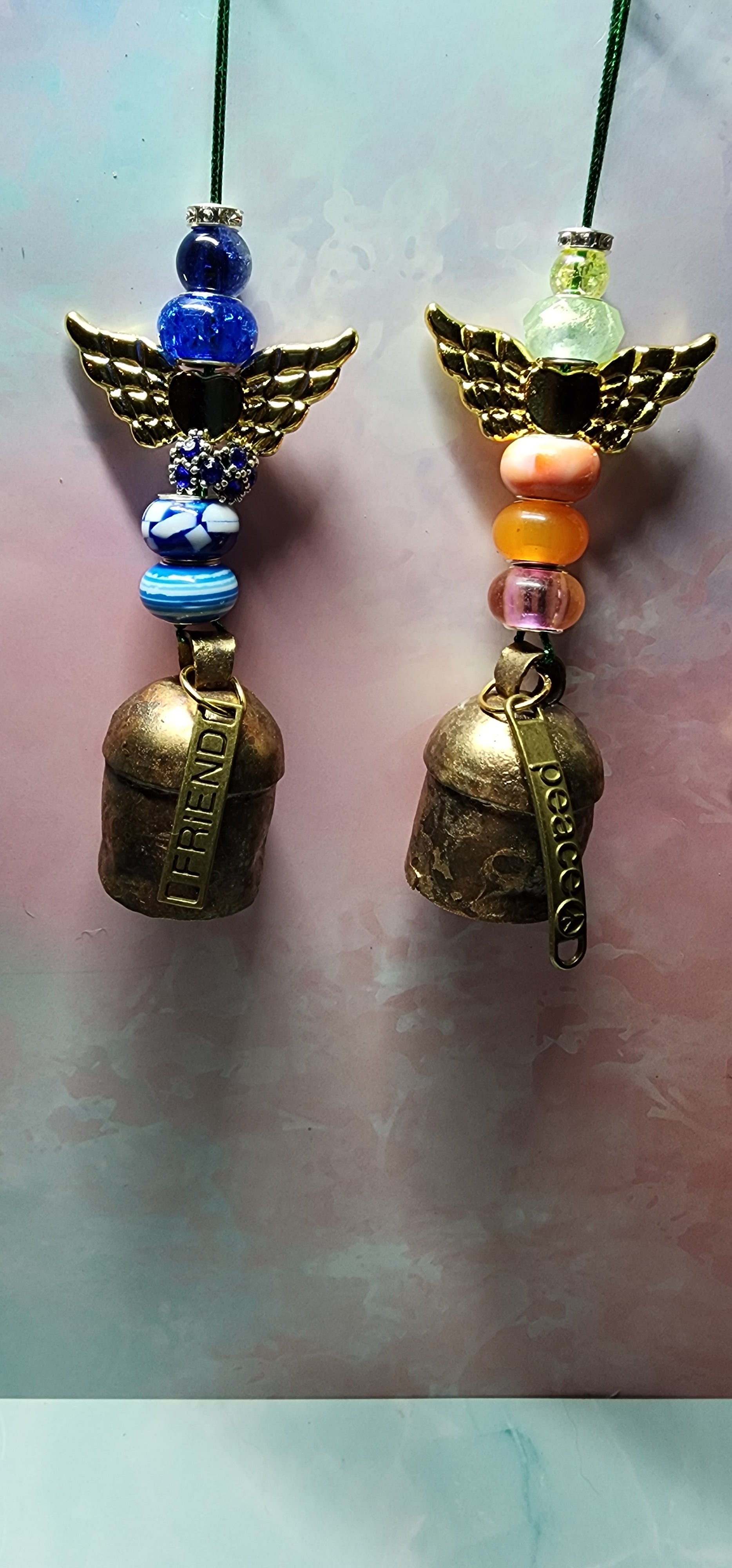 Beautiful colorful glass angel Christmas ornaments with a melodic bell and inspiring charm attached on bottom.