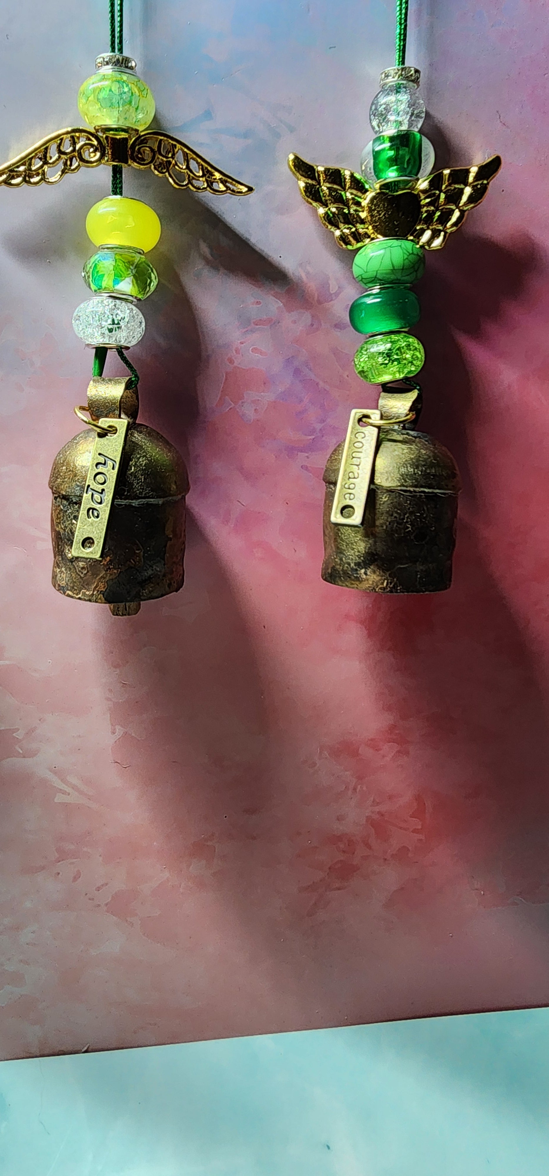 Beautiful colorful glass angel Christmas ornaments with a melodic bell and inspiring charm attached on bottom.