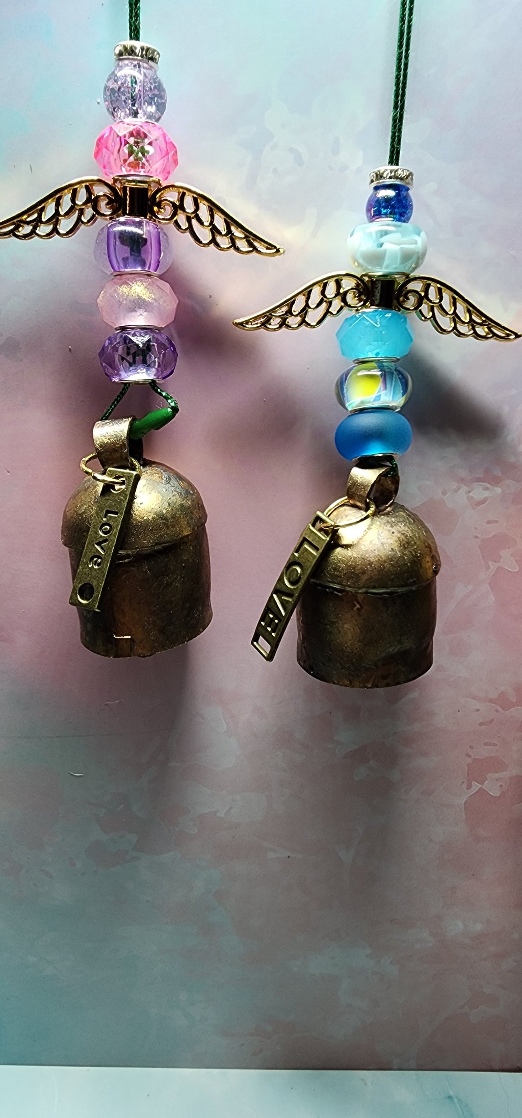 Beautiful colorful glass angel Christmas ornaments with a melodic bell and inspiring charm attached on bottom.