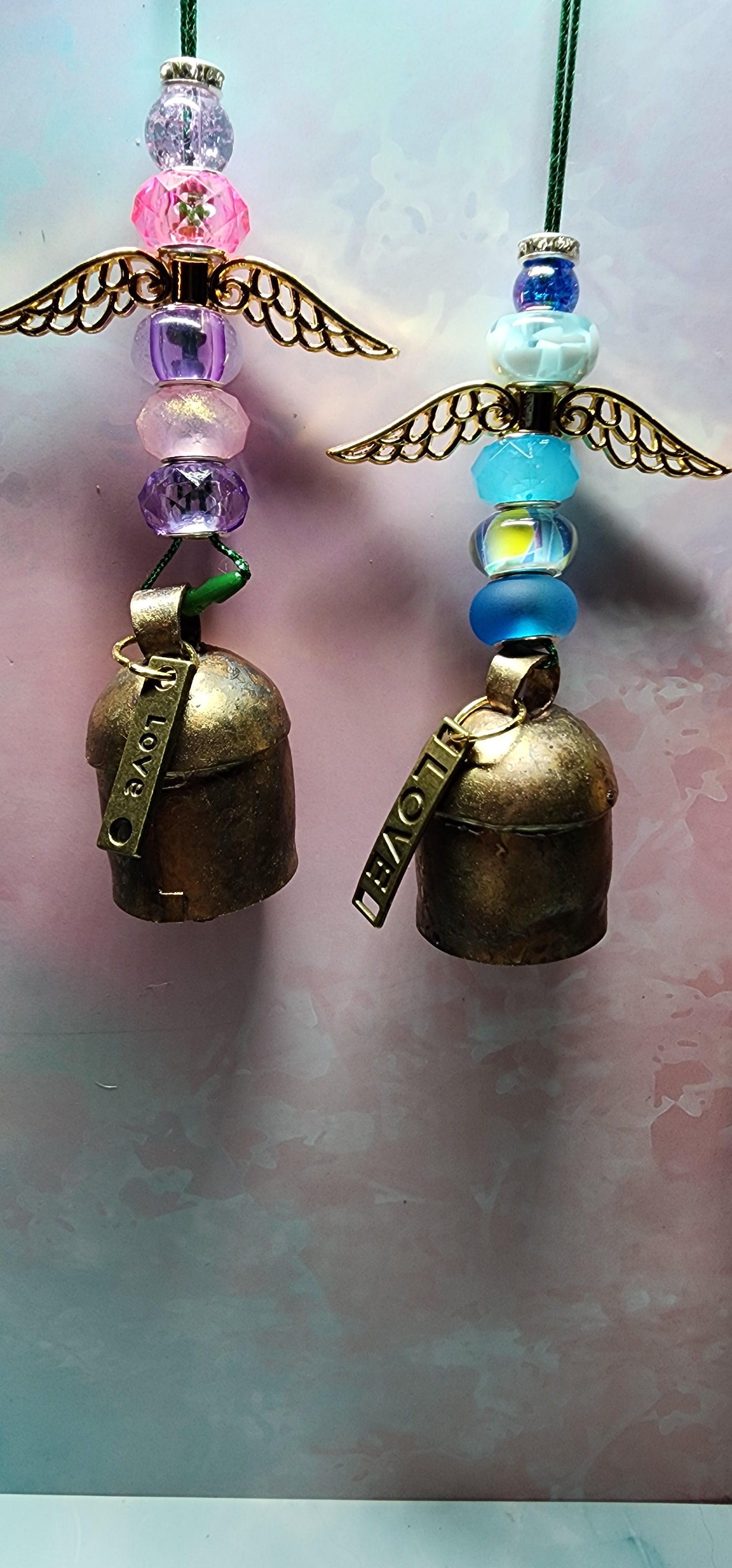 Beautiful colorful glass angel Christmas ornaments with a melodic bell and inspiring charm attached on bottom.
