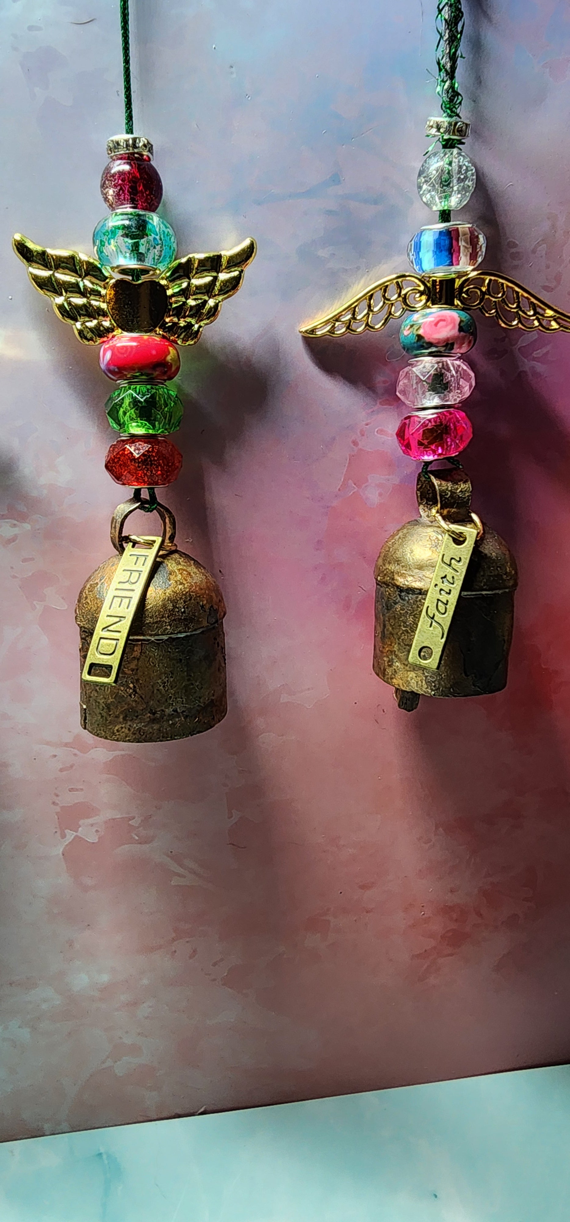 Beautiful colorful glass angel Christmas ornaments with a melodic bell and inspiring charm attached on bottom.