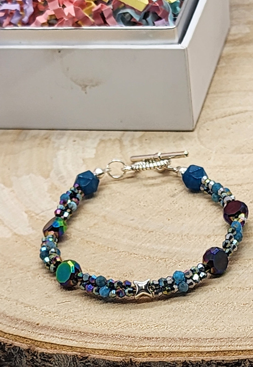 Multicolored beaded bracelet on a wooden surface with a white background
