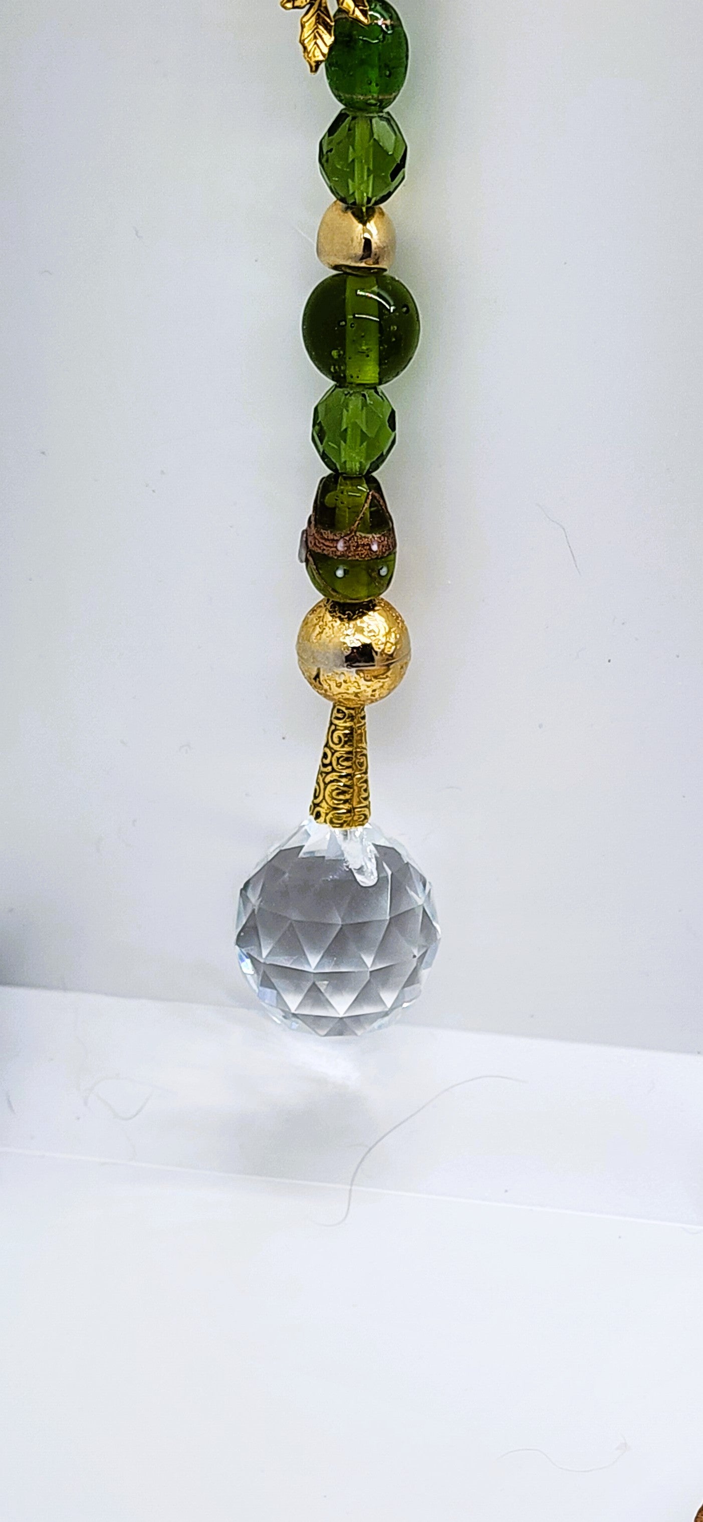 Handmade Green Glass Suncatcher with 30mm Crystal Prism and gold-colored accents